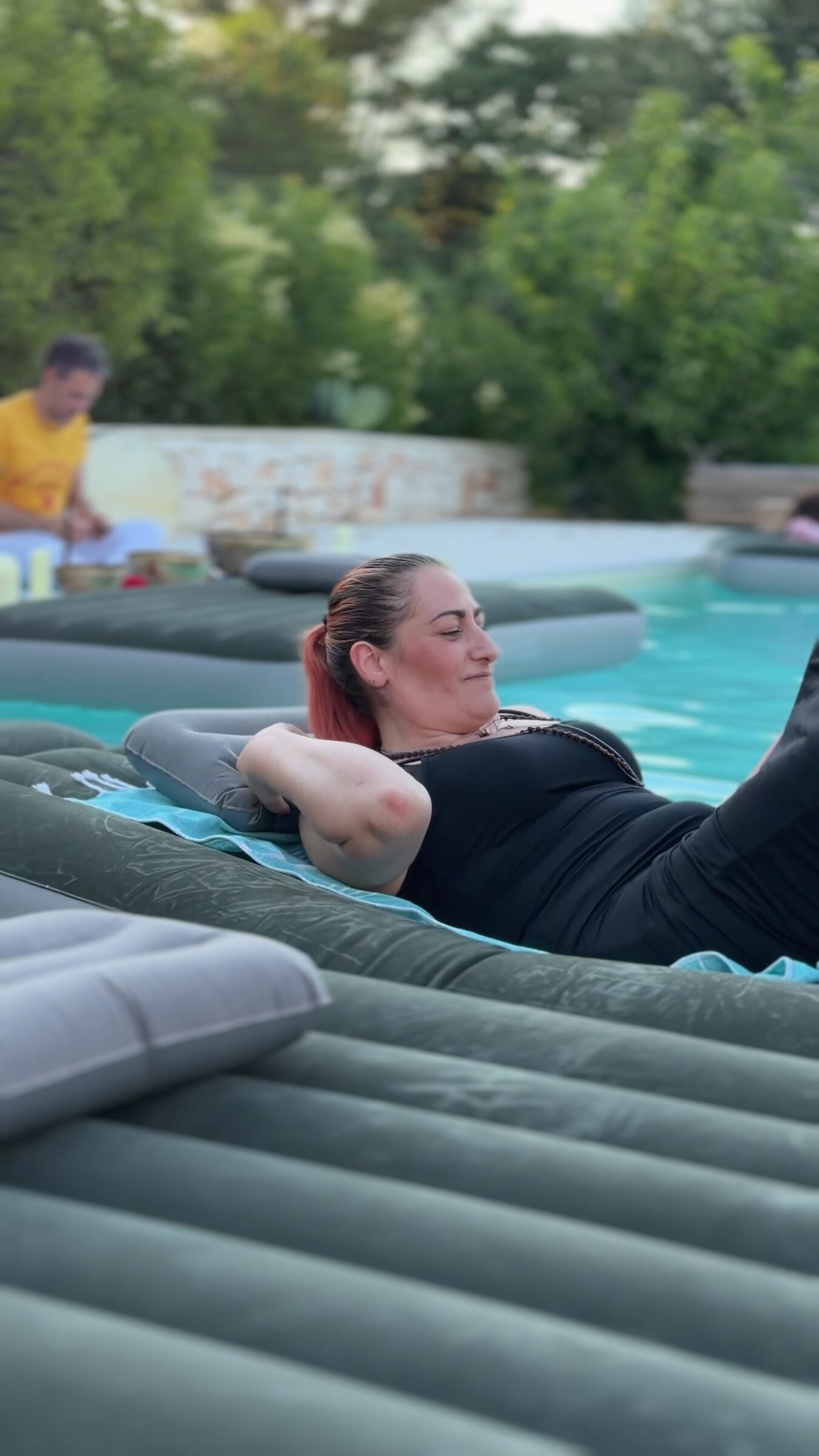 Ospite che galleggia sul lettino in piscina al tramonto